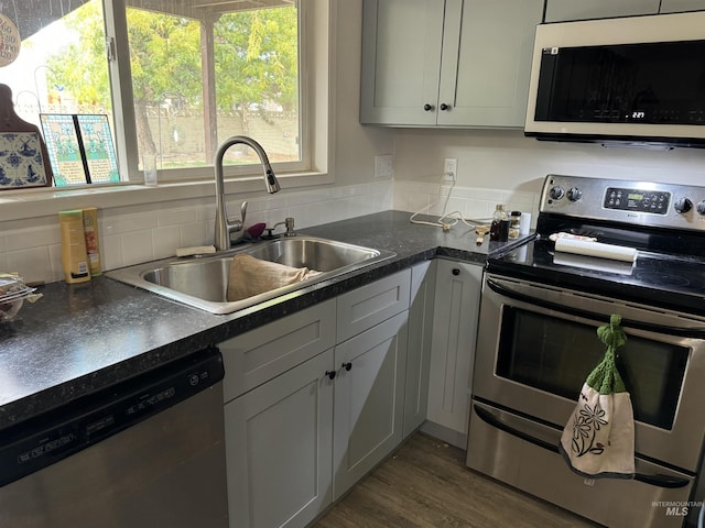 1111 SW 11th Ave, Ontario, OR 97914 - kitchen featuring dark countertops, appliances with stainless steel finishes, dark wood-style flooring, and a sink
