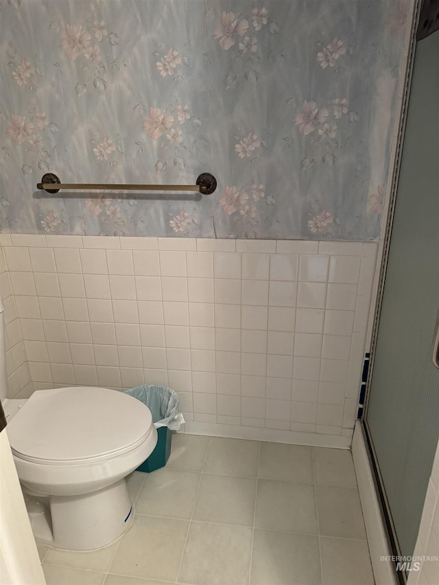 1111 SW 11th Ave, Ontario, OR 97914 - full bathroom with wallpapered walls, a shower with door, tile walls, toilet, and tile patterned flooring