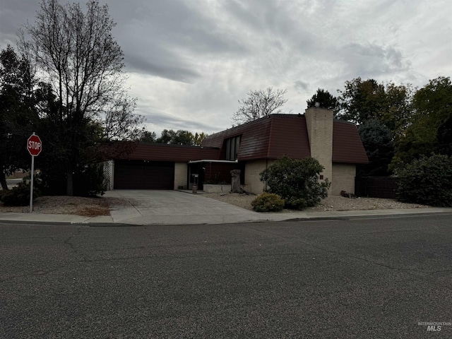 1111 SW 11th Ave, Ontario, OR 97914 - view of front of home featuring concrete driveway, a chimney, and a garage