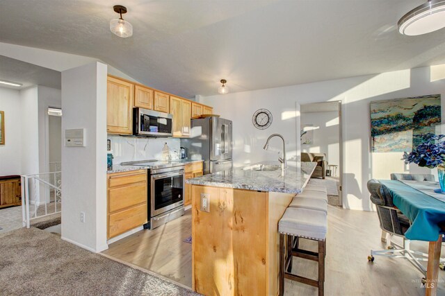 4420 N Ginzel St, Boise, ID 83703 - kitchen featuring backsplash, light brown cabinetry, a kitchen breakfast bar, stainless steel appliances, and a sink
