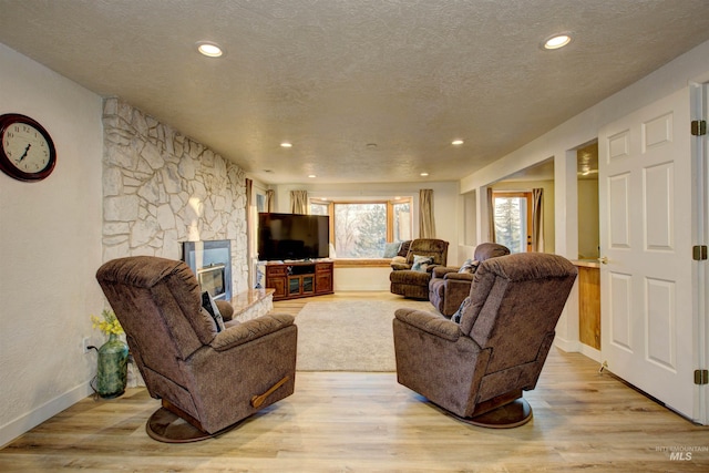 4420 N Ginzel St, Boise, ID 83703 - living room featuring a textured ceiling, recessed lighting, a fireplace, light wood finished floors, and baseboards