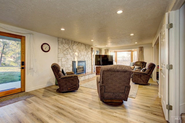 4420 N Ginzel St, Boise, ID 83703 - living room with recessed lighting, a fireplace, light wood-type flooring, and a textured ceiling