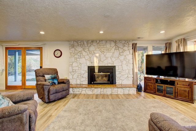 4420 N Ginzel St, Boise, ID 83703 - living room featuring recessed lighting, a textured ceiling, a stone fireplace, and light wood finished floors