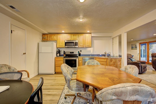4420 N Ginzel St, Boise, ID 83703 - kitchen featuring visible vents, light wood-style flooring, light brown cabinets, a textured ceiling, and appliances with stainless steel finishes