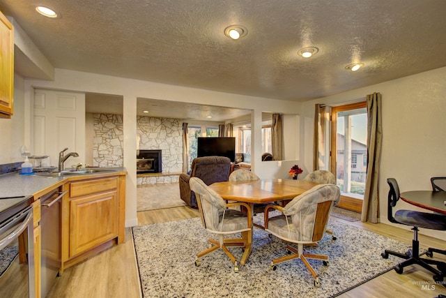 4420 N Ginzel St, Boise, ID 83703 - dining room featuring recessed lighting, light wood-type flooring, a textured ceiling, and a fireplace