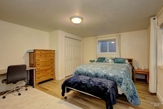 4420 N Ginzel St, Boise, ID 83703 - bedroom featuring a closet, baseboards, light wood-style floors, and a textured ceiling
