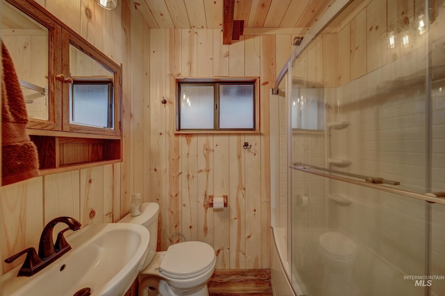 full bathroom with sink, wooden walls, wood ceiling, and toilet