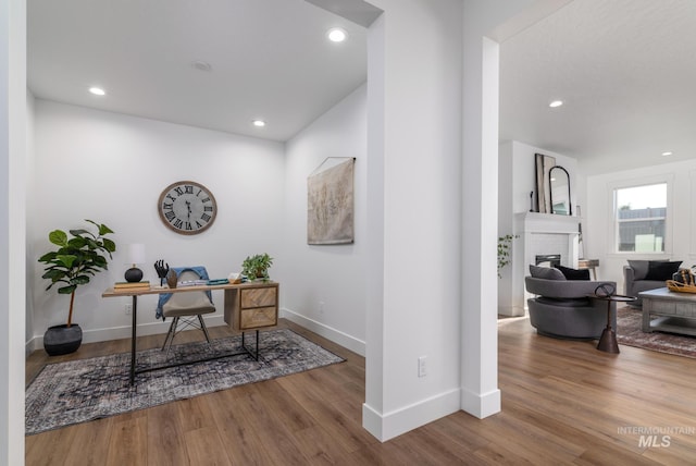 office area with a fireplace and hardwood / wood-style floors