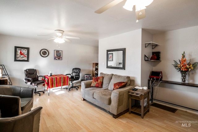 living room featuring visible vents, a ceiling fan, and light wood-style floors