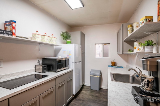 kitchen with open shelves, stainless steel microwave, gray cabinetry, a sink, and black electric cooktop