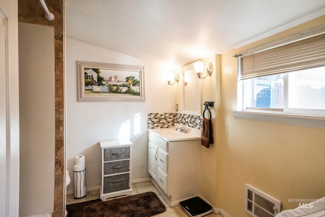 bathroom with vanity, visible vents, vaulted ceiling, a shower, and decorative backsplash