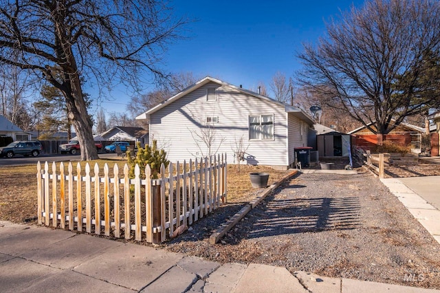 view of property exterior featuring driveway and a fenced front yard