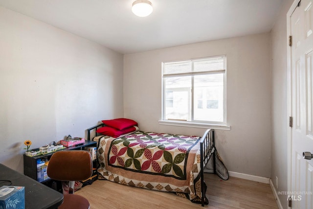 bedroom featuring baseboards and wood finished floors