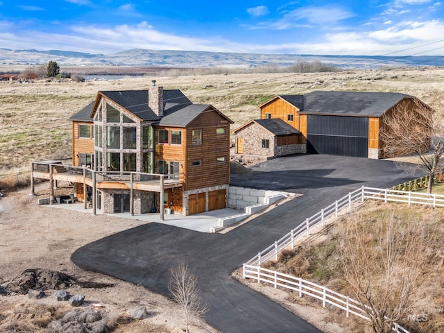 13331 Peaceful Way, Nampa, ID 83686 - exterior space with fence, stone siding, a patio, a deck with mountain view, and a chimney