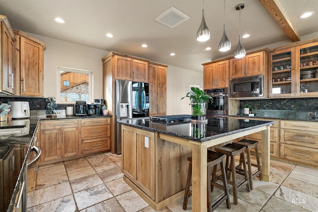13331 Peaceful Way, Nampa, ID 83686 - kitchen featuring appliances with stainless steel finishes, recessed lighting, a kitchen island, visible vents, and stone tile flooring