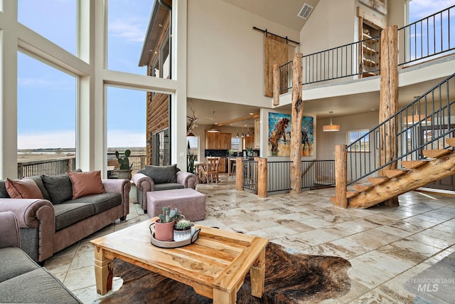 13331 Peaceful Way, Nampa, ID 83686 - living area featuring visible vents, a towering ceiling, a wealth of natural light, and stone tile flooring