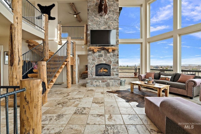 13331 Peaceful Way, Nampa, ID 83686 - living room with stone tile floors, a stone fireplace, stairway, and a towering ceiling