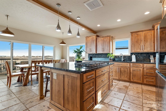13331 Peaceful Way, Nampa, ID 83686 - kitchen with a sink, stainless steel gas stovetop, backsplash, visible vents, and stone tile flooring