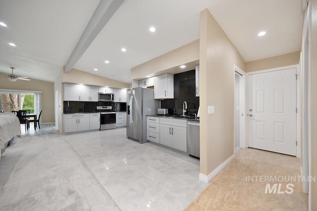 kitchen featuring backsplash, vaulted ceiling with beams, ceiling fan, appliances with stainless steel finishes, and white cabinetry