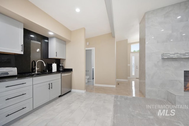 kitchen with dishwasher, decorative backsplash, white cabinetry, and sink