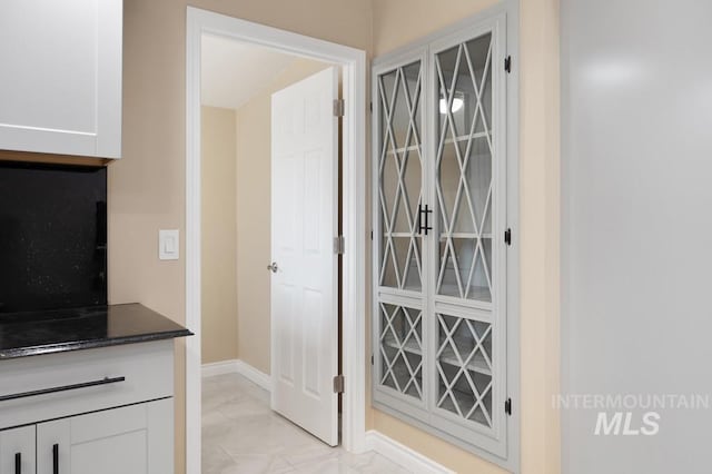 interior space featuring dark stone countertops and white cabinets