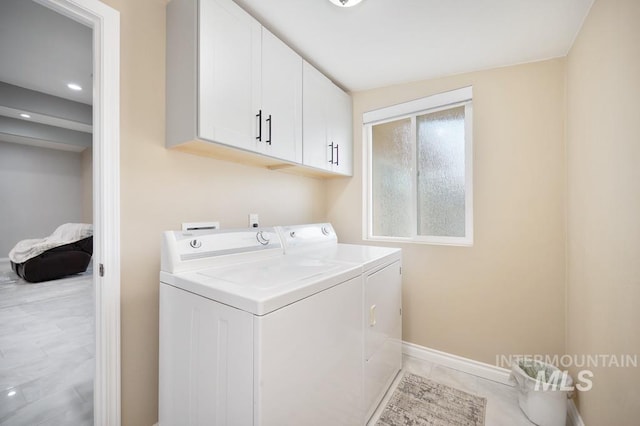 washroom featuring cabinets, light tile patterned floors, and washer and dryer