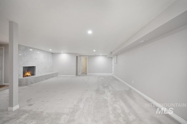 basement with a fireplace and carpet