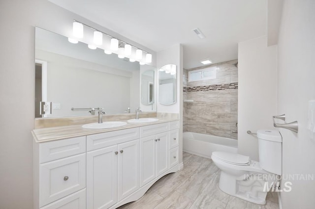 full bathroom featuring vanity, tiled shower / bath combo, and toilet