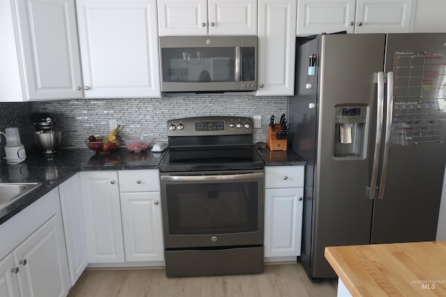 2405 23rd St, Clarkston, WA 99403 - kitchen with appliances with stainless steel finishes, white cabinets, backsplash, and light wood-style flooring