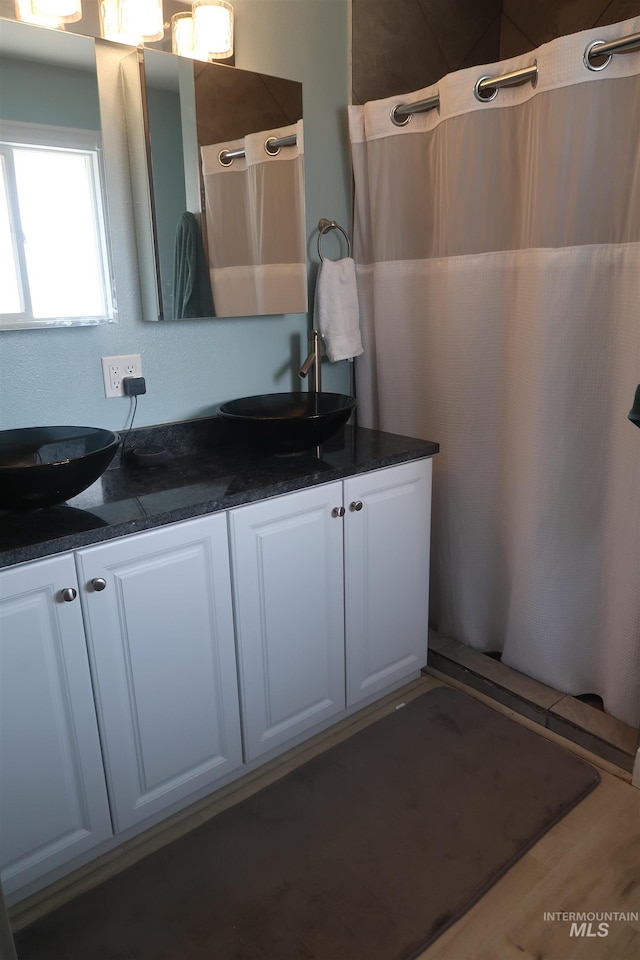 2405 23rd St, Clarkston, WA 99403 - full bath featuring double vanity, wood finished floors, and a shower with shower curtain