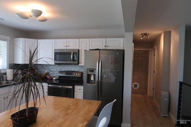 2405 23rd St, Clarkston, WA 99403 - kitchen with stainless steel appliances, wood finished floors, white cabinets, backsplash, and wood counters