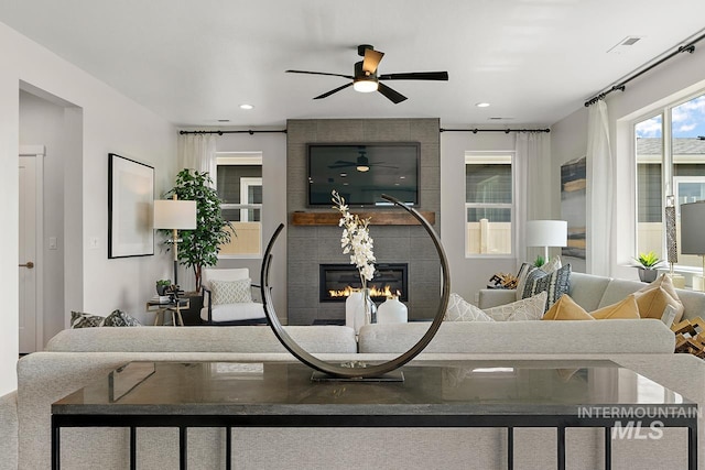 living area with recessed lighting, visible vents, and a large fireplace