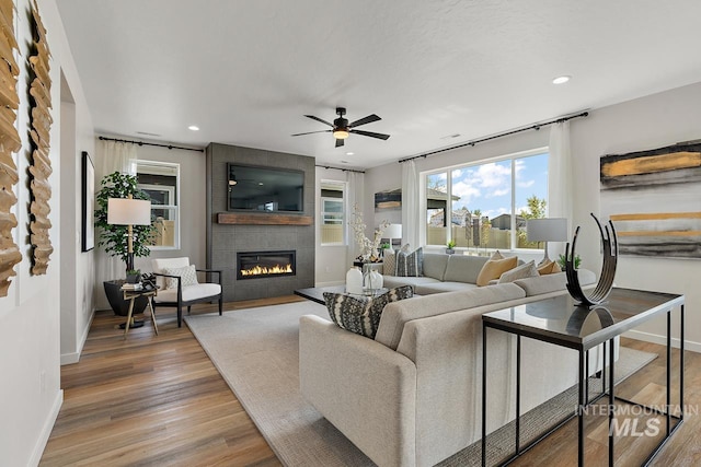 living room with light wood finished floors, recessed lighting, and a fireplace