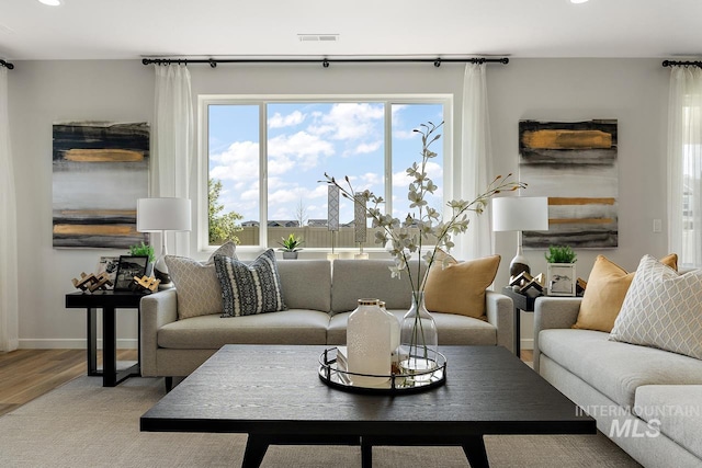 living area featuring recessed lighting, visible vents, baseboards, and wood finished floors