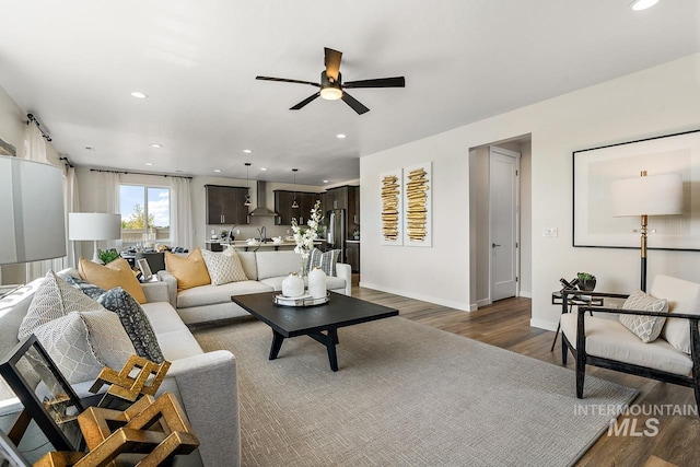 living area with recessed lighting, a ceiling fan, baseboards, and wood finished floors