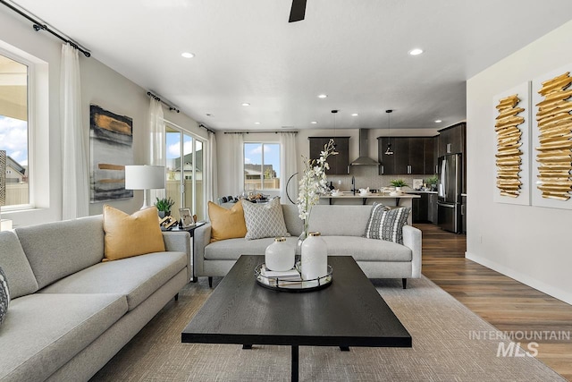 living room with recessed lighting, baseboards, and dark wood-style flooring