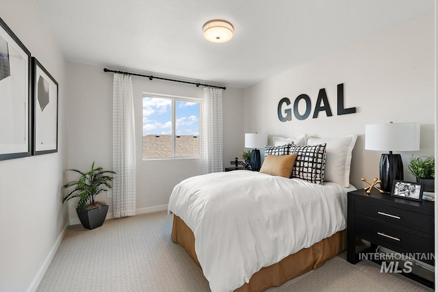 bedroom with light carpet and baseboards