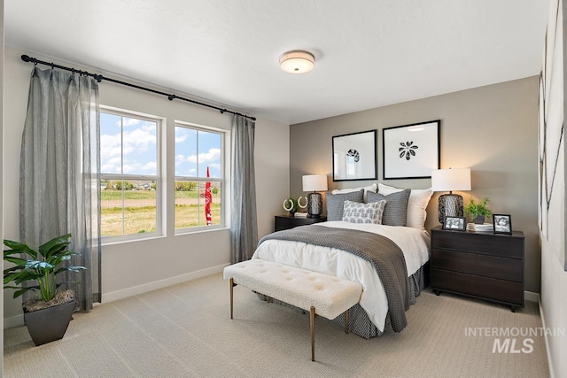 bedroom with baseboards and light colored carpet