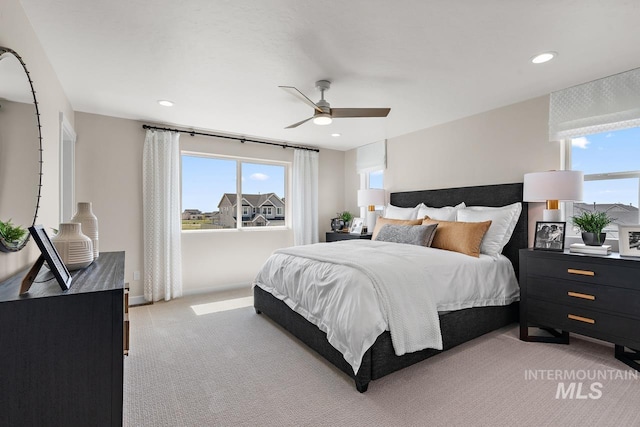 bedroom with multiple windows, light colored carpet, and recessed lighting