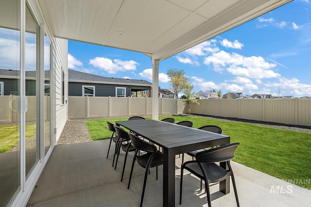 view of patio featuring outdoor dining space, a fenced backyard, and a residential view