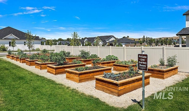 view of yard with a garden, a residential view, and fence