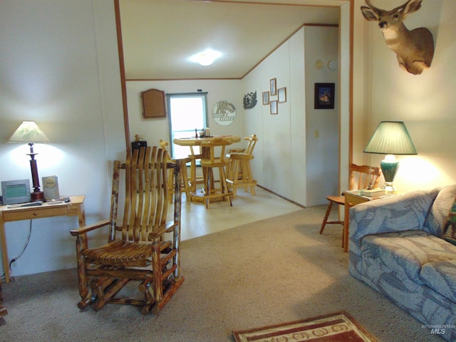 living area featuring vaulted ceiling, crown molding, and carpet floors