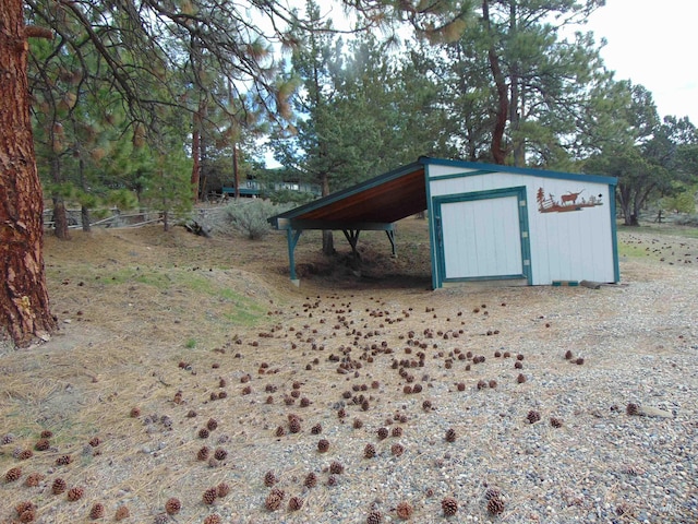 view of outdoor structure with a carport and an outbuilding