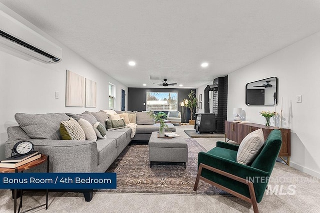 carpeted living room with ceiling fan, a wood stove, a textured ceiling, and a wall unit AC