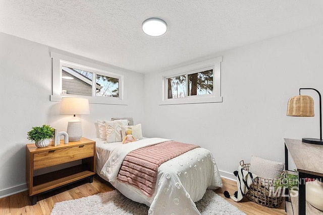 bedroom featuring a textured ceiling and light wood-type flooring