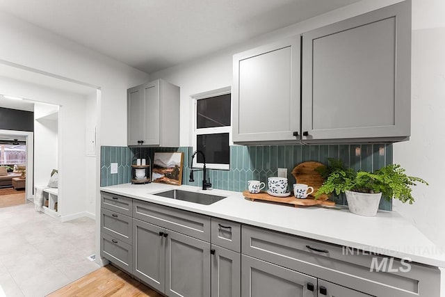 kitchen with sink, gray cabinetry, and backsplash