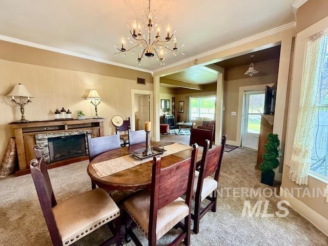407 1st St, Asotin, WA 99402 - carpeted dining space with a chandelier, crown molding, and a fireplace