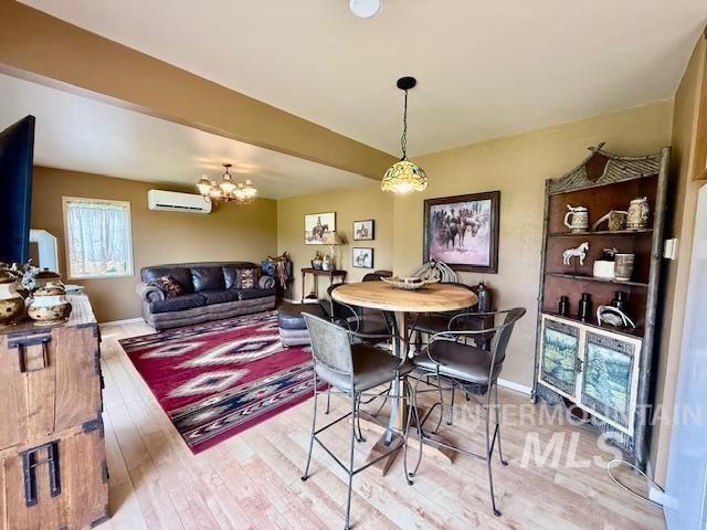 407 1st St, Asotin, WA 99402 - dining space with an AC wall unit, wood finished floors, and a chandelier
