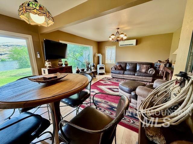 407 1st St, Asotin, WA 99402 - living area featuring a wall mounted air conditioner, wood finished floors, and a chandelier