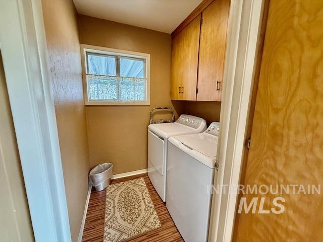 407 1st St, Asotin, WA 99402 - laundry area featuring independent washer and dryer, cabinet space, and wood finished floors